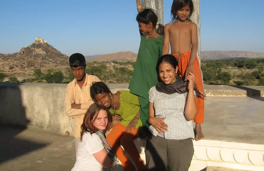 Children playing outdoor games with volunteers after class