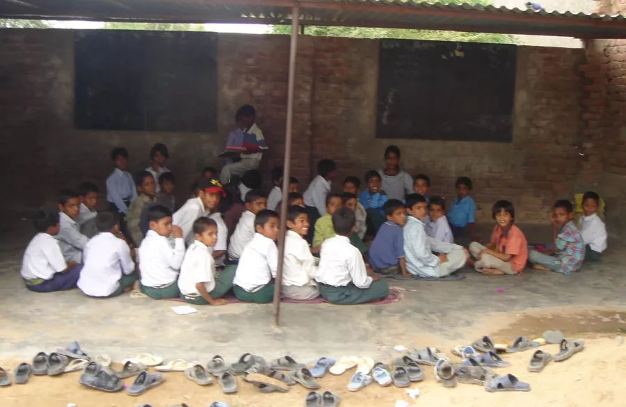 Volunteer helping a student with writing practice in Hindi and English