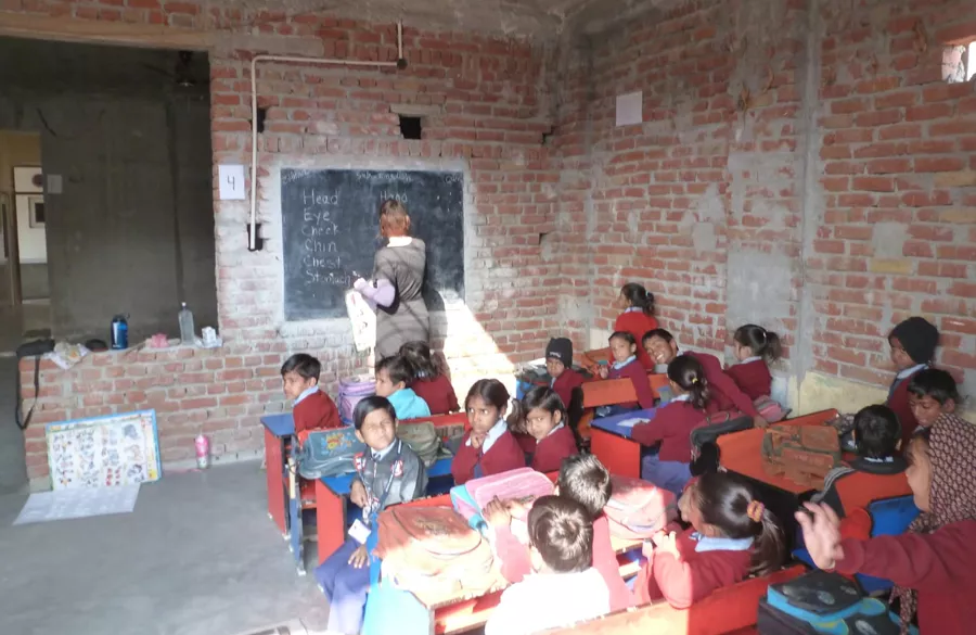 Volunteer and teacher planning lesson for rural classroom